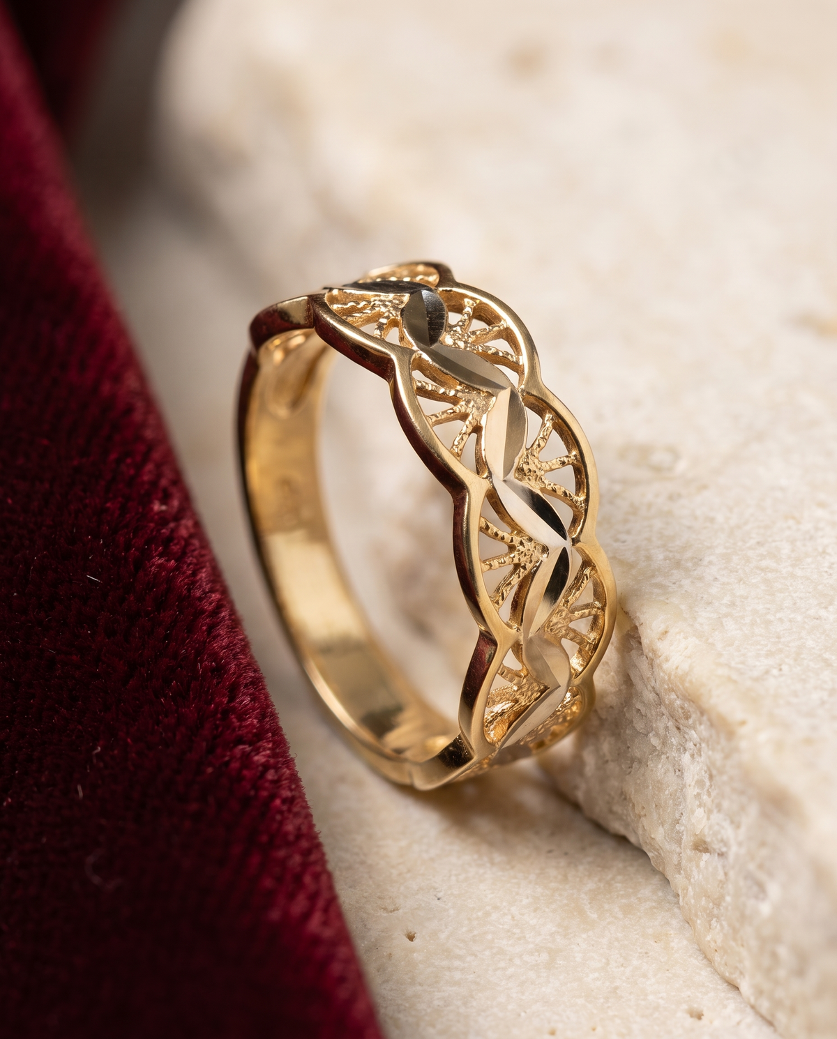 Anello in oro 18 carati con lavorazione traforata intrecciata su pietra e velluto rosso