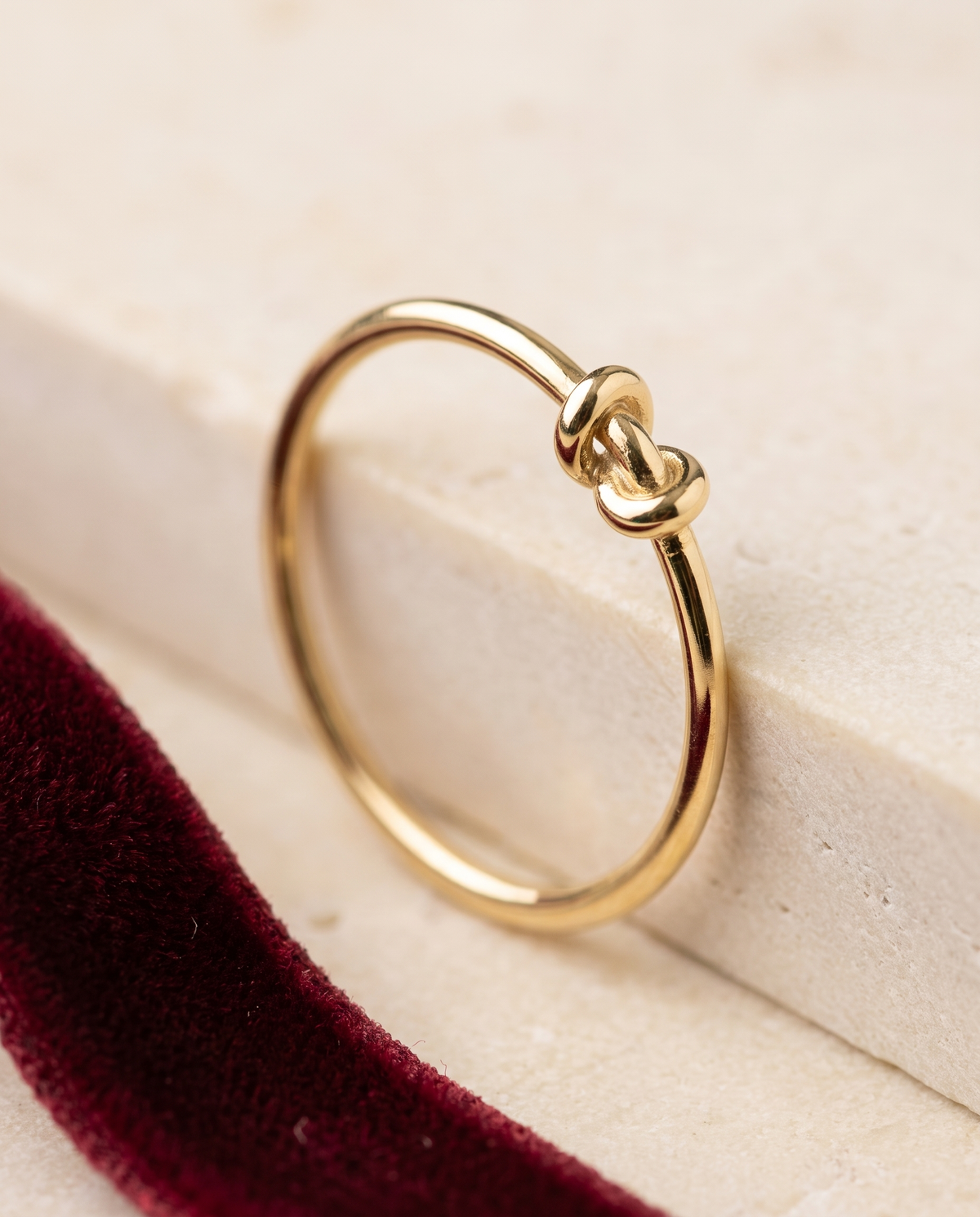Anello Nodo in oro 18 carati su pietra chiara e velluto rosso