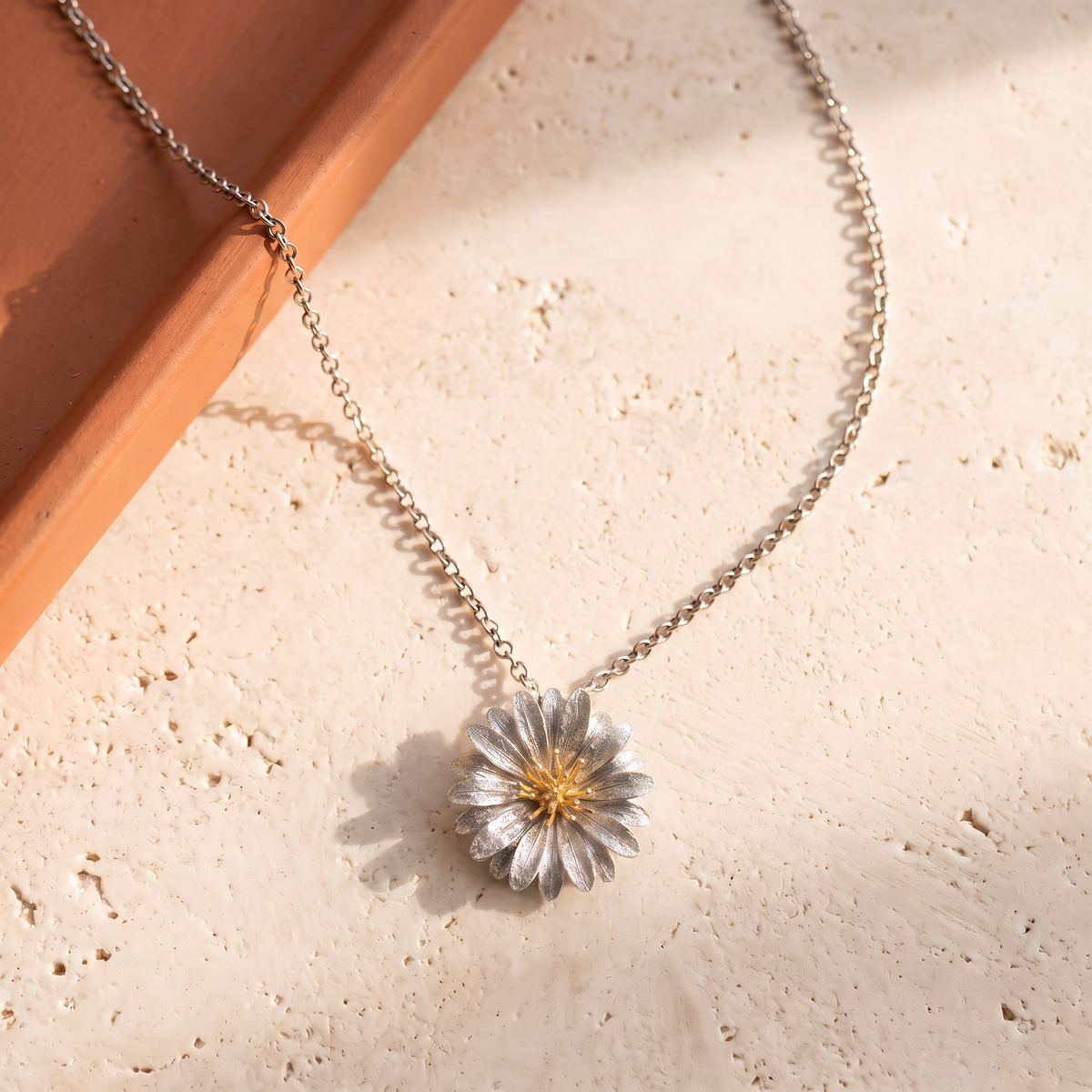 Collana Fioritura della collezione Terra in argento con centro dorato, vista completa su pietra chiara