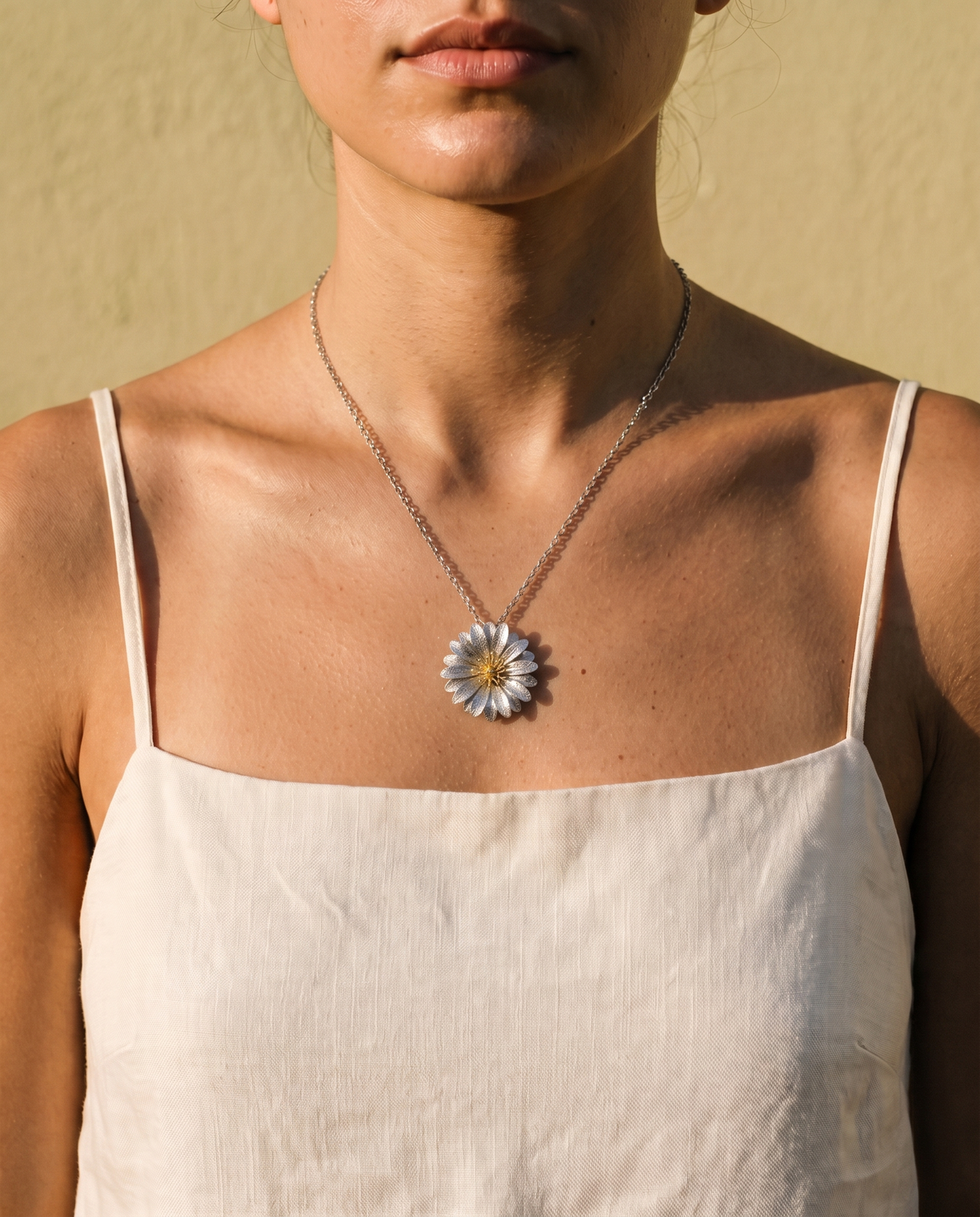 Collana Fioritura Terra indossata, con ciondolo floreale bicolore di 2,5 cm