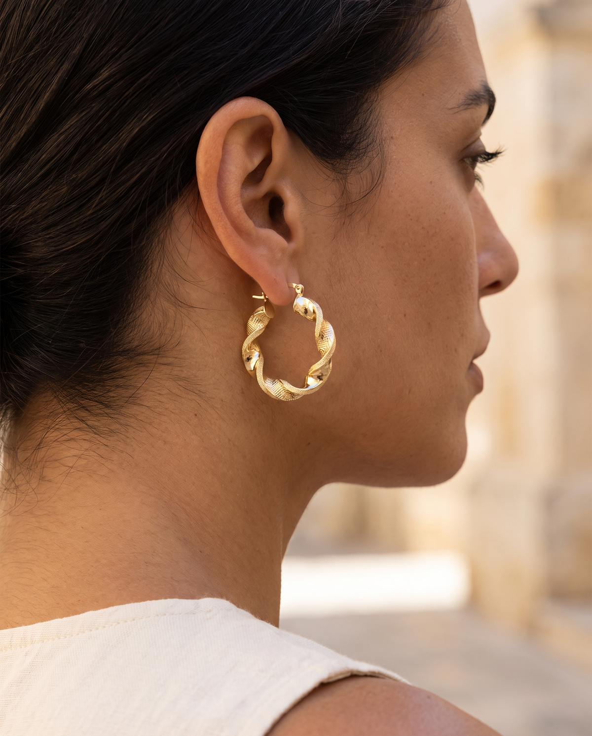 Orecchini Intreccio Gold 18kt Piccolo indossati da donna mediterranea