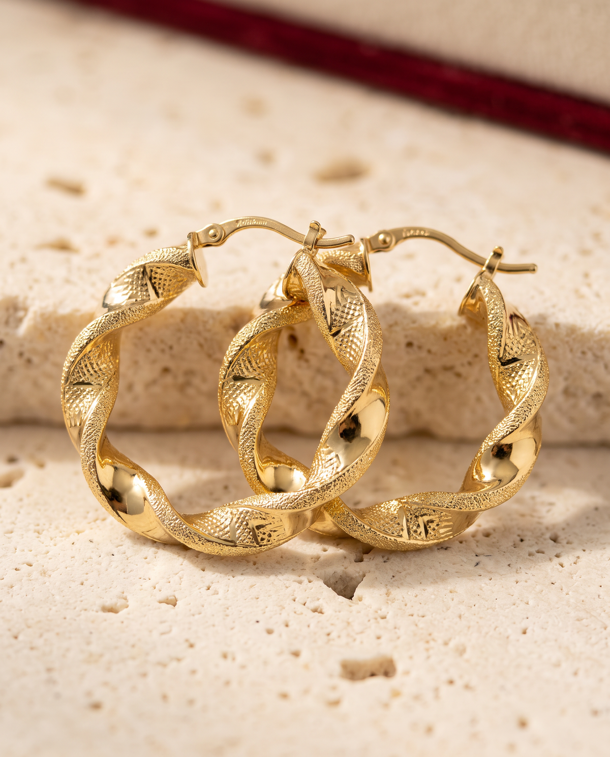 Orecchini Intreccio Gold 18kt misura Piccolo, macro su pietra chiara