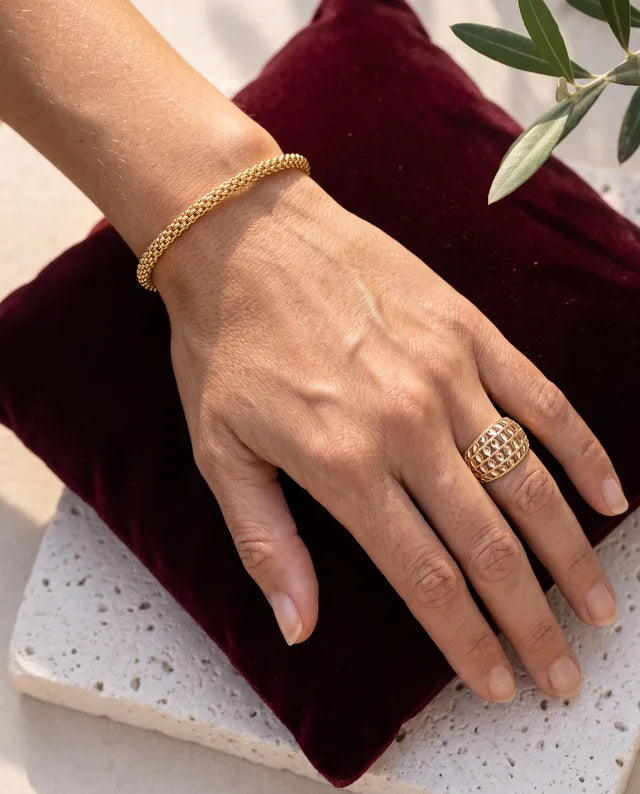 Getragenes Luce-Armband aus 18-karätigem Gold auf bordeauxrotem Samt